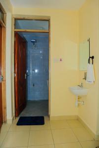 a bathroom with a shower and a sink and a sink at 3 Jays Homes in Narok