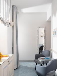 a room with two chairs and a table and a mirror at Boutique Hotel Casa Mariantonia in Anacapri