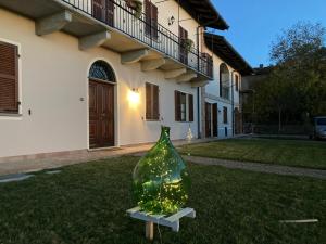 a glass bottle sitting in the grass in front of a house at Casa vacanze Martina in Castagnole Lanze