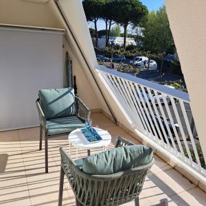 a balcony with two chairs and a table and a staircase at T2 West CITY Parking Clim Wifi 4pers - ROSSIconciergerie - Linge inclus in La Grande-Motte