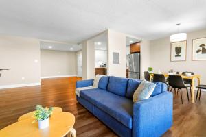 アーリントンにあるCrystal City Escape Stylish Apt Close to DC Airportの青いソファとテーブルのあるリビングルーム +15枚の写真