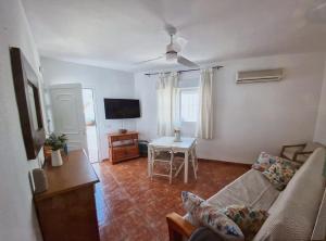 a living room with a couch and a table at Duplex Barbados Aguamarga in Agua Amarga