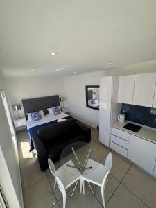 a bedroom with a bed and a table and a couch at Carpe Diem in Langebaan