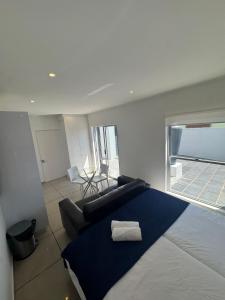 a bedroom with a bed and a couch and a window at Carpe Diem in Langebaan
