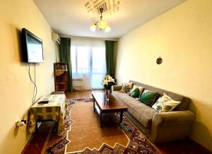 een woonkamer met een bank en een tafel bij Ssenyange City Apartment in Varna