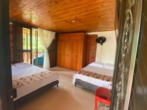 a bedroom with two beds and a wooden ceiling at Villa Natalia in Montenegro