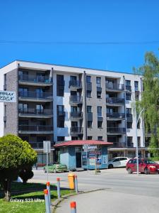 PožegaにあるApartman Miljaの駐車場付きの大型アパートメントビル