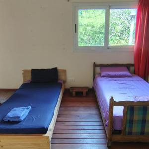 two beds in a room with a window at La Casa Azul in San Javier