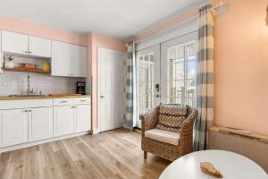 eine Küche mit weißen Schränken, einem Tisch und einem Stuhl in der Unterkunft Steps to Beach and Boardwalk Pineapple Retreat in Hampton