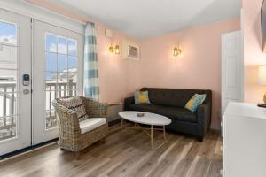 ein Wohnzimmer mit Sofa und Tisch in der Unterkunft Steps to Beach and Boardwalk Pineapple Retreat in Hampton + 44 Fotos