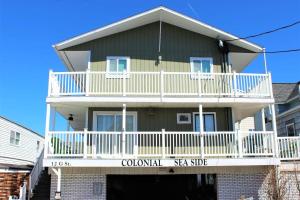 ein großes Haus mit einem weißen Balkon in der Unterkunft Steps to Beach and Boardwalk Pineapple Retreat in Hampton