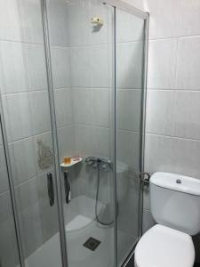 a shower with a glass door next to a toilet at -Precioso apartamento en pleno corazón de A Guarda in A Guarda +12 photos