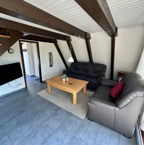 a living room with a leather couch and a coffee table at Natur Pur-Waldurlaub im Tiny House in Ronshausen