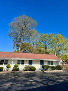a white building with a red roof at Chisholm's Motor Inn in Saugus