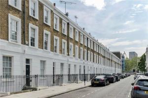 a long line of cars parked in front of a building at Elegant and Modern 3-Bedroom Victorian House in Westminster, London in London