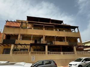 a tall building with cars parked in front of it at Brisa y Mar Aguadulce II in Aguadulce