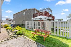 a picnic table with an umbrella next to a fence at Steps to Beach Salisbury Shore House #1 AC in Salisbury