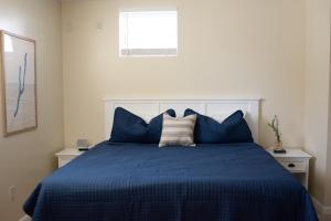 a bedroom with a blue bed with blue pillows at Hubbs Cellar at JS Hubbs Guest House in Hammondsport