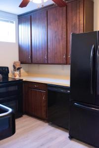 a kitchen with a black refrigerator and wooden cabinets at Hubbs Cellar at JS Hubbs Guest House in Hammondsport