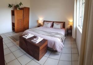 a bedroom with a bed and a table with towels on it at Cottage with Farmyard Garden on the Sunshine Coast in Alexandria