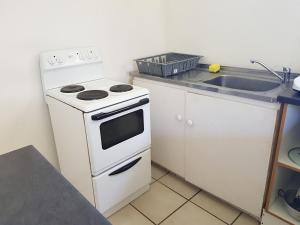 a kitchen with a white stove and a sink at Cottage with Farmyard Garden on the Sunshine Coast in Alexandria +20 photos
