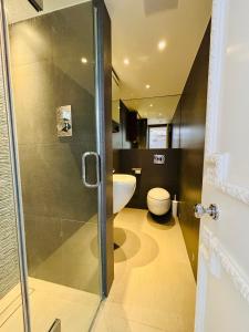 a bathroom with a toilet and a glass shower door at Elegant and Modern 3-Bedroom Victorian House in Westminster, London in London +17 photos