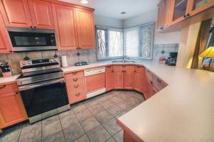 a kitchen with wooden cabinets and a stove top oven at Sunnyside Knoll- 6 cabin in Estes Park