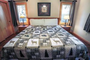 a bedroom with a bed with a quilt on it at Sunnyside Knoll- 6 cabin in Estes Park