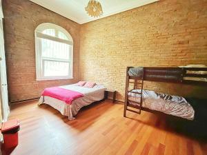 a bedroom with a bunk bed and a brick wall at La Casa Piola in Valparaíso