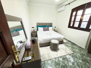 a small bedroom with a bed and a mirror at Marrakech Art in Marrakech