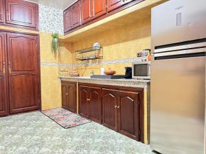 a kitchen with wooden cabinets and a stainless steel refrigerator at Marrakech Art in Marrakech +8 photos