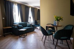 a living room with a couch and chairs and a table at Apartamenty Drevny Kocur in Poznań