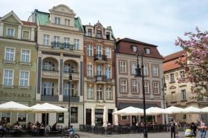 a group of buildings on a street with tables and chairs at Apartamenty Drevny Kocur in Poznań