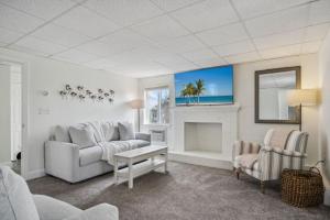 un salon avec un canapé et une cheminée dans l'établissement Basin Breeze Cottage AC Decks Water Views, à Newburyport