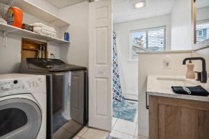 une cuisine avec une machine à laver et un évier dans l'établissement Basin Breeze Cottage AC Decks Water Views, à Newburyport