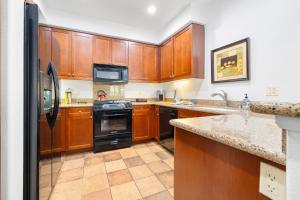 a kitchen with wooden cabinets and a black refrigerator at LV262 2BR 2BA Legacy Villa with Mnt Views in La Quinta