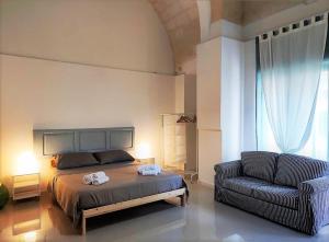 a bedroom with a bed and a couch and a chair at La Piazza in San Giorgio Ionico
