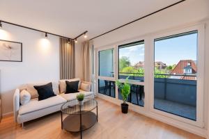 a living room with a couch and a large window at Malu Rooms - im Zentrum, Kostenloser Parkplatz, Balkon, Netflix, 24h Checkin in Ludwigsburg