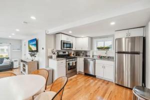 a kitchen with white cabinets and stainless steel appliances at Beachfront Parking Salisbury Beach Retreat in Salisbury