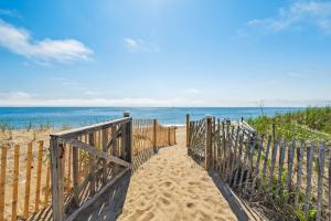 a wooden pathway to the beach with the ocean in the background at Beachfront Parking Salisbury Beach Retreat in Salisbury