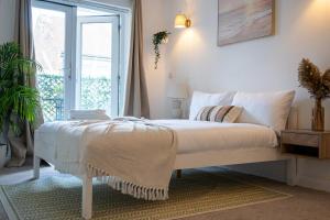 朴次茅斯Central Apt En Suites with Pool table and Private Balcony的卧室里有一张白色的床，还有一扇窗户