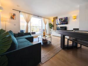 朴次茅斯Central Apt En Suites with Pool table and Private Balcony的客厅配有蓝色的沙发和钢琴