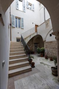 ein Torbogen, der zu einem Gebäude mit Treppen führt in der Unterkunft Casa Piccolomini in Ascoli Piceno