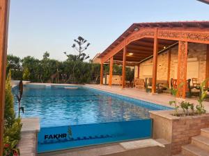 a swimming pool in front of a house at Amoun sea view in Qaryat Shurūq