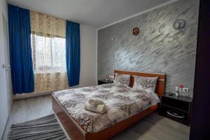 a bedroom with a large bed with blue curtains at Pensiunea Nituca in Moisei