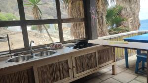 a kitchen with a sink and a view of the beach at Black Mamba in Paul