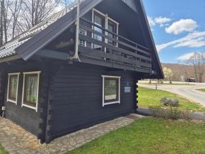 a black house with a balcony on the side of it at Edison,Plitvice Lakes in Jezerce