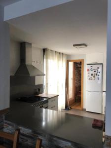 a kitchen with a stove and a white refrigerator at Alojamiento rural con encanto in Alborache +18 photos