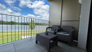 a balcony with two chairs and a view of the water at Bluewave riverside Piešťany in Banka