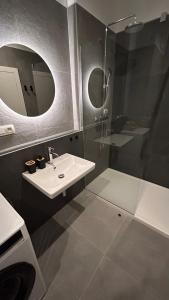 a bathroom with a sink and a shower with a mirror at Bluewave riverside Piešťany in Banka +5 photos